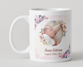 White mug with a photo of a baby and floral design on a light gray background