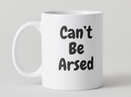 White mug with 'Can't Be Arsed' text on a light gray background