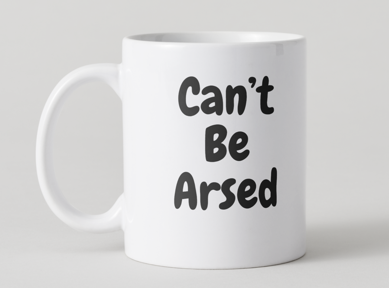 White mug with 'Can't Be Arsed' text on a light gray background