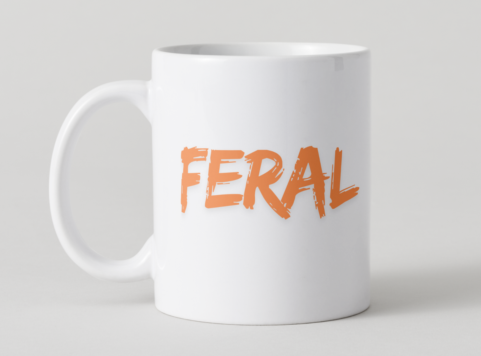 White mug with 'FERAL' printed in orange on a light gray background