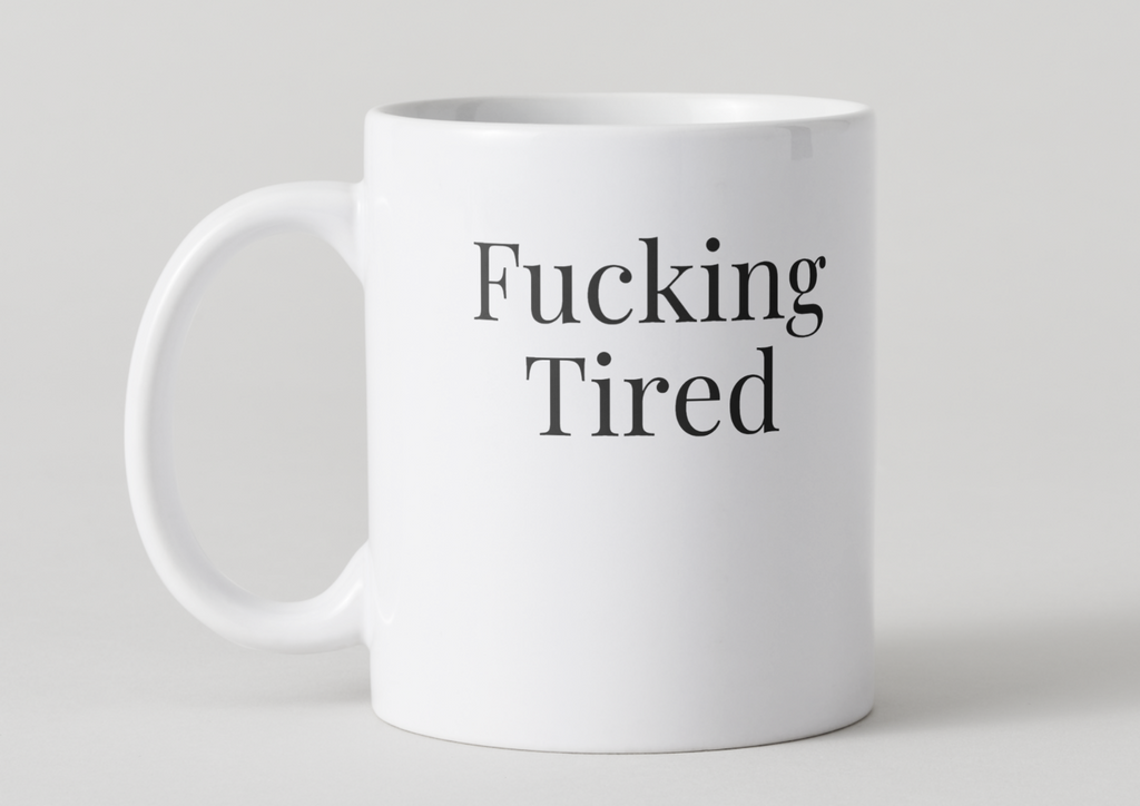 White mug with 'Fucking Tired' text on a light gray background