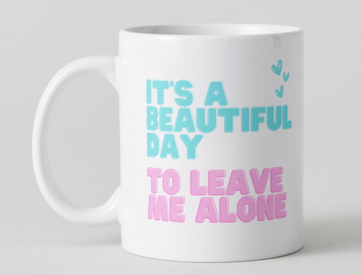 White mug with blue and pink text on a light gray background