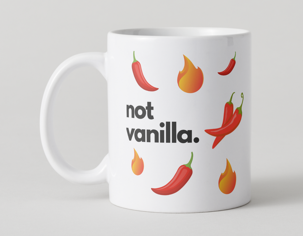 White mug with red chili peppers and flames, and the text 'not vanilla' on a light gray background.