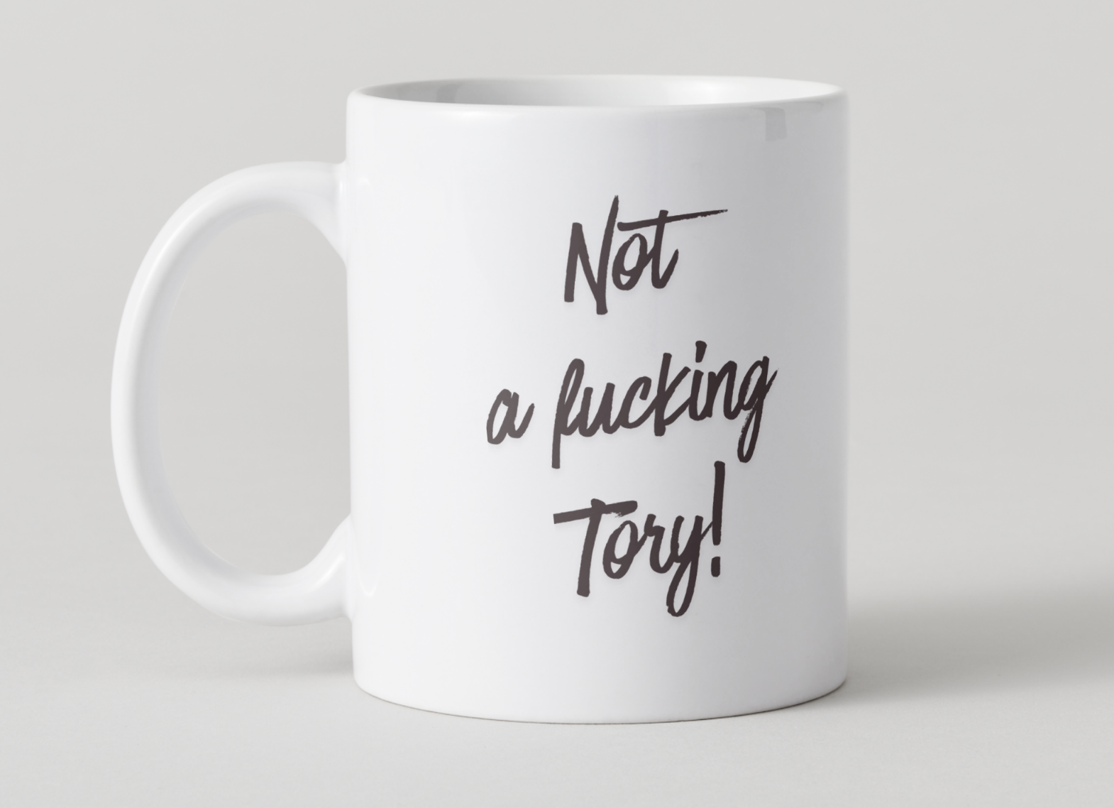 White mug with black text 'Not a fucking Tory!' on a light gray background