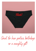 Black underwear with 'Slut!' printed on it against a pink background, with promotional text below.