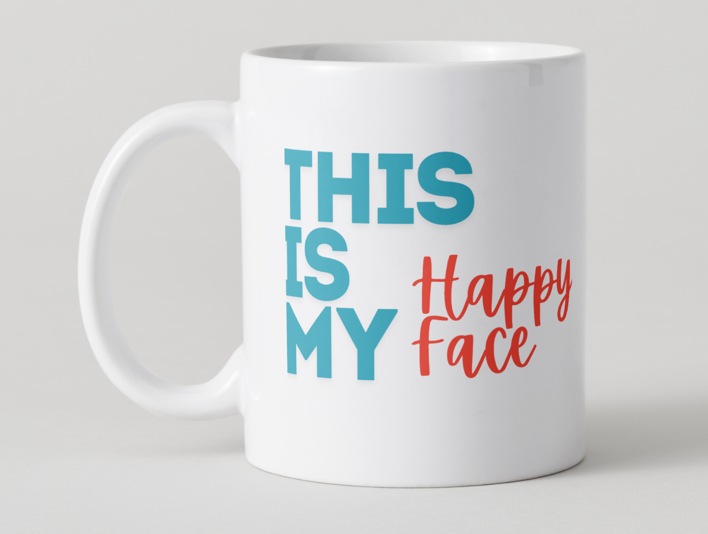 White mug with colorful text 'THIS IS MY Happy Face' on a light gray background