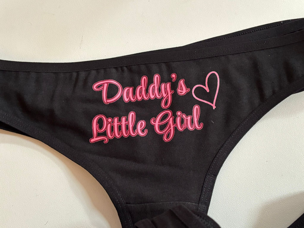 Black bralette with pink embroidered text reading 'Daddy's Little Girl' and a heart outline on the front, shown on a light background.
