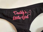 Black bralette with pink embroidered text reading 'Daddy's Little Girl' and a heart outline on the front, shown on a light background.
