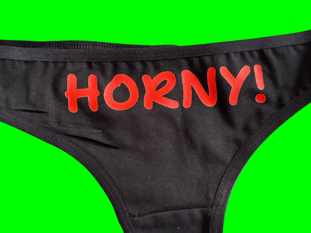 Black underwear with the word 'HORNY!' printed vertically in red text on the side, shown against a light background.